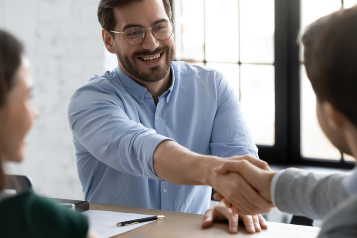 Smiling businessmen handshake closing deal at office meeting